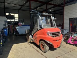 Oranje heftruck voor het verplaatsen van metalen