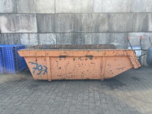 Oranje container voor oud ijzer op locatie
